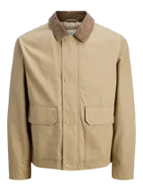 Campera utility de manga larga color beige, con cuello camisero de pana marrón. Tiene cierre de botones, dos bolsillos frontales con solapa y un interior forrado en poliéster reciclado. Cuenta con acabado repelente al agua.