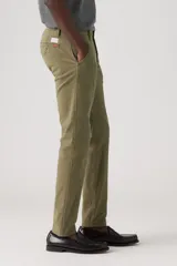 Pantalón chino color verde oliva, de corte slim, con tiro medio y confeccionado en tela sin elasticidad.
