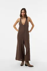 Mono de lino color marrón, de corte relajado, con escote en V pronunciado, breteles anchos y pantalón de pierna amplia.