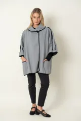 Chaquetón italiano rayado en tonos de natural y negro con vivos en negro. Modelo cruzado que se prende con un botón, amplios bolsillos delanteros y calce holgado.