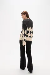 Sweater de tejido jacquard con diseño de rombos en colores azul marino y rojo, de corte holgado, manga larga y cuello redondo.