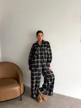 Pantalón de corte recto y holgado, confeccionado en tela de viyela con estampado de cuadros en tonos negro, gris y blanco. Presenta cintura elástica para mayor comodidad.