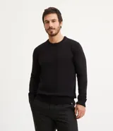 Suéter negro de tejido de punto pesado, con cuello redondo y mangas largas.