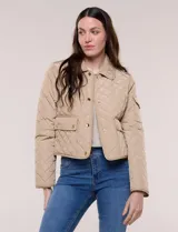 Campera corta capitoneada Michael Kors de color beige, con diseño acolchado en rombos, cuello camisero, cierre frontal de botones metálicos a presión y bolsillos frontales con solapa. Incluye un pequeño bolsillo en la manga.