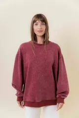 Sweater de tejido de punto color bordó con efecto lavado vintage, de calce oversize, cuello redondo y puños acanalados.