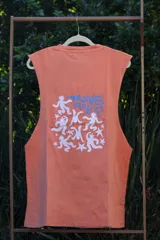 Musculosa sin mangas color naranja quemado, con cuello redondo y sisas amplias. Estampado frontal en blanco con figuras estilizadas y texto.