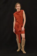 Vestido corto sin mangas de satén color marrón, con cuello buche, hombros caídos y un lazo ajustable en la cintura.
