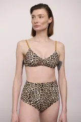 Top de bikini tipo triángulo con estampado animal print de leopardo y tirantes finos en color mostaza.