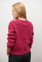 Buzo de punto con cuello redondo, manga larga y textura jaspeada en tonos beige y crema.