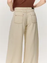 Pantalón ancho de denim azul, de tiro alto y corte holgado y fluido con perneras amplias.