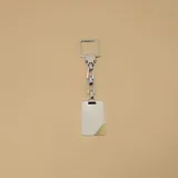 Llavero plateado con dije rectangular con detalle dorado en una esquina, unido por una cadena de eslabones a un aro cuadrado.