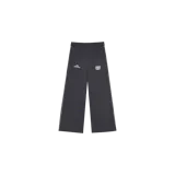 Pantalón de jogging Eme Studios modelo Referee Sweatpants de corte ancho, color gris oscuro con patrón de rayas diplomáticas. Presenta una línea blanca lateral en cada pierna, cintura elástica y detalles bordados en el frente, incluyendo un logo tipográfico y un escudo heráldico.