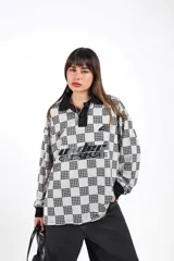 Casaca unisex de manga larga, con cuello tejido negro y estampado a cuadros en blanco crudo y negro.