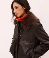 Campera de cuero sintético marrón con efecto desteñido, cuello alto y solapa de piel sintética desmontable. Cuenta con cierre frontal, bolsillos delanteros con solapa y elástico en el ruedo.