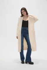 Saco largo tipo cárdigan abierto, confeccionado en tejido de punto con diseño de ochos en las mangas y laterales. Presenta un frente liso con bordes acanalados y un calce holgado.