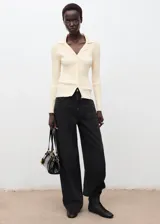 Pantalón de jean negro de tiro medio, con diseño estilo barrel o balloon, corte amplio y cinco bolsillos.