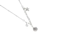 Collar de acero plateado con cadena de eslabones gruesos y finos. Presenta tres dijes colgantes: una estrella de mar con incrustaciones de circones, una circonia redonda y una concha marina.