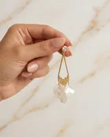Caravanas colgantes con baño de oro, compuestas por un perno con cristal, una estructura geométrica triangular y pétalos de nácar colgantes.