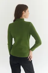 Polera de tejido morley color azul, con cuello alto y mangas largas, de corte ajustado al cuerpo.