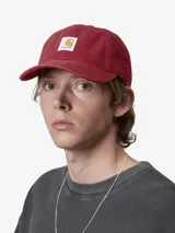 Gorra tipo baseball de Carhartt, confeccionada en lona de algodón color bordó, con parche rectangular con el logo de la marca en el frente.