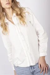 Camisa negra de manga larga con cuello clásico, cierre frontal con botones y volados verticales en el frente.