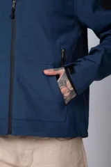 Campera de abrigo color azul, con cierre frontal, capucha ajustable y bolsillos laterales con cierre. Presenta un diseño minimalista con detalle de logo circular en la manga.