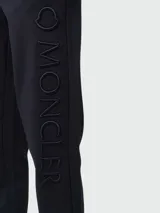 Pantalón deportivo de algodón color azul marino, con cintura elástica ajustable mediante cordón, bolsillos laterales y puños acanalados en los tobillos.
