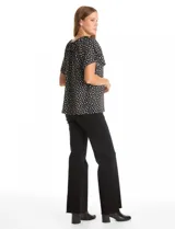 Blusa de crepe con estampado geométrico en blanco y negro, cuello redondo elastizado con frunces y mangas cortas amplias.