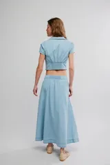 Conjunto de dos piezas de denim celeste, compuesto por un top corto de mangas cortas con escote en V y botonadura frontal, y una falda midi abotonada al frente.