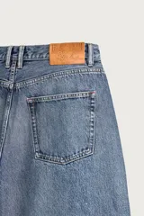 Jeans baggy fit de tiro medio, confeccionados en denim de algodón con efecto lavado. Presentan un diseño de cinco bolsillos, corte holgado y amplio en toda la pierna, con cierre frontal de botones.
