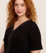 Blusa negra de viscosa con escote en V, mangas cortas y detalle de hilo metalizado en el frente.