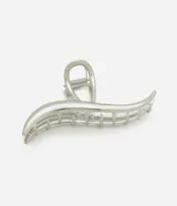 Pinza para el pelo plateada con forma ondulada y detalle calado.