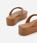 Ojotas negras con plataforma plana, tiras anchas y puntera redonda.