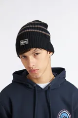 Gorro de lana negro con rayas horizontales en tonos marrones y morados en la parte superior, diseño de punto acanalado y parche bordado con el logo de Quiksilver al frente.