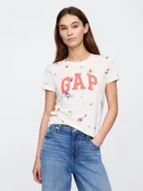 Remera de algodón color crema con estampado floral disperso y el logo de la marca GAP en color coral en el centro del pecho.
