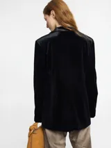 Blazer negro de terciopelo con solapa de satén y cierre con dos botones.