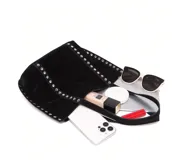 Bolso tote negro de gamuza con tachas plateadas en los laterales y doble asa de hombro.