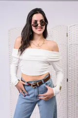 Remera blanca de manga larga con escote off-shoulder y diseño fruncido en el escote.