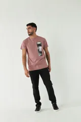 Remera de manga corta color malva/rosado con cuello redondo y un arte estampado vertical en blanco y negro en el frente.