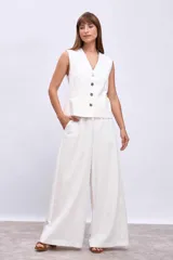Chaleco blanco con cuello en V y cierre frontal con botones.