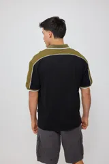 Remera polo negra con corte en hombros y mangas en color verde oliva, con ribete blanco.