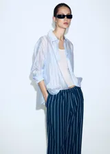 Pantalón de corte recto y tiro regular, confeccionado en algodón con diseño de rayas verticales. Presenta cintura elástica con cordón ajustable y bolsillos laterales.