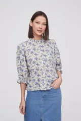 Blusa de viscosa con estampado floral, cuello a la base con detalle de volados, cierre frontal con botones y mangas tres cuartos abullonadas con puños elásticos.