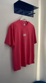 Remera de manga corta color fucsia, con cuello redondo y corte relajado. Presenta el logo "DROPZ" centrado en el pecho en color blanco.