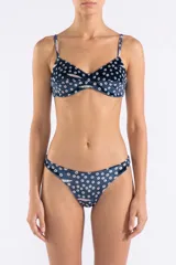 Bombacha de bikini con estampado original de círculos y detalles sobre fondo azul, confeccionada en poliamida reciclada y elastano, con diseño de tiro alto y laterales cavados.