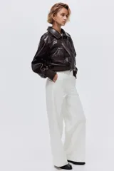 Pantalón de jean blanco de corte wide leg y tiro alto, con diseño de pierna amplia, bolsillos laterales al bies y raya marcada en el frente.