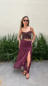 Pollera larga color uva, de gasa con base fruncida, transparencias y volados verticales.