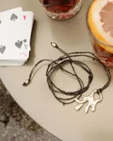 Collar con dije de bronce macizo con forma orgánica irregular, similar a un coral, suspendido de un cordón negro de seda natural anudado.