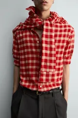 Camisa de corte relajado confeccionada en tejido de mezcla de viscosa y lana con acabado de franela. Presenta un diseño de cuadros en tonos rojo y beige, cuello con botones, cierre frontal de botones y mangas largas con puños abotonados.