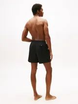 Short de baño Tommy Hilfiger de corte amplio, con diseño color block que incorpora los colores icónicos de la marca (negro, blanco, azul marino y rojo) en la parte frontal. Cuenta con cintura elástica con cordón ajustable, dos bolsillos laterales y un bolsillo trasero de ojal.